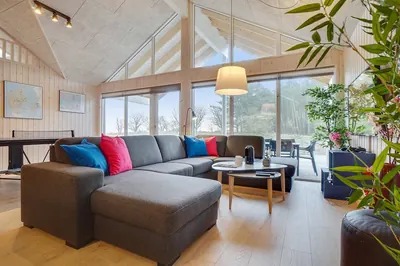 Opholdsstuen med stor hjørnesofa og vinduer ud mod haven